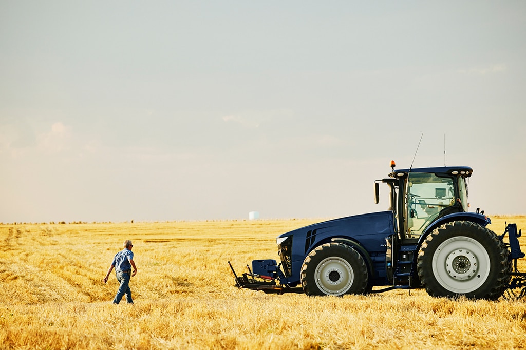 Trattore in un campo di grano con olio idraulico per motore